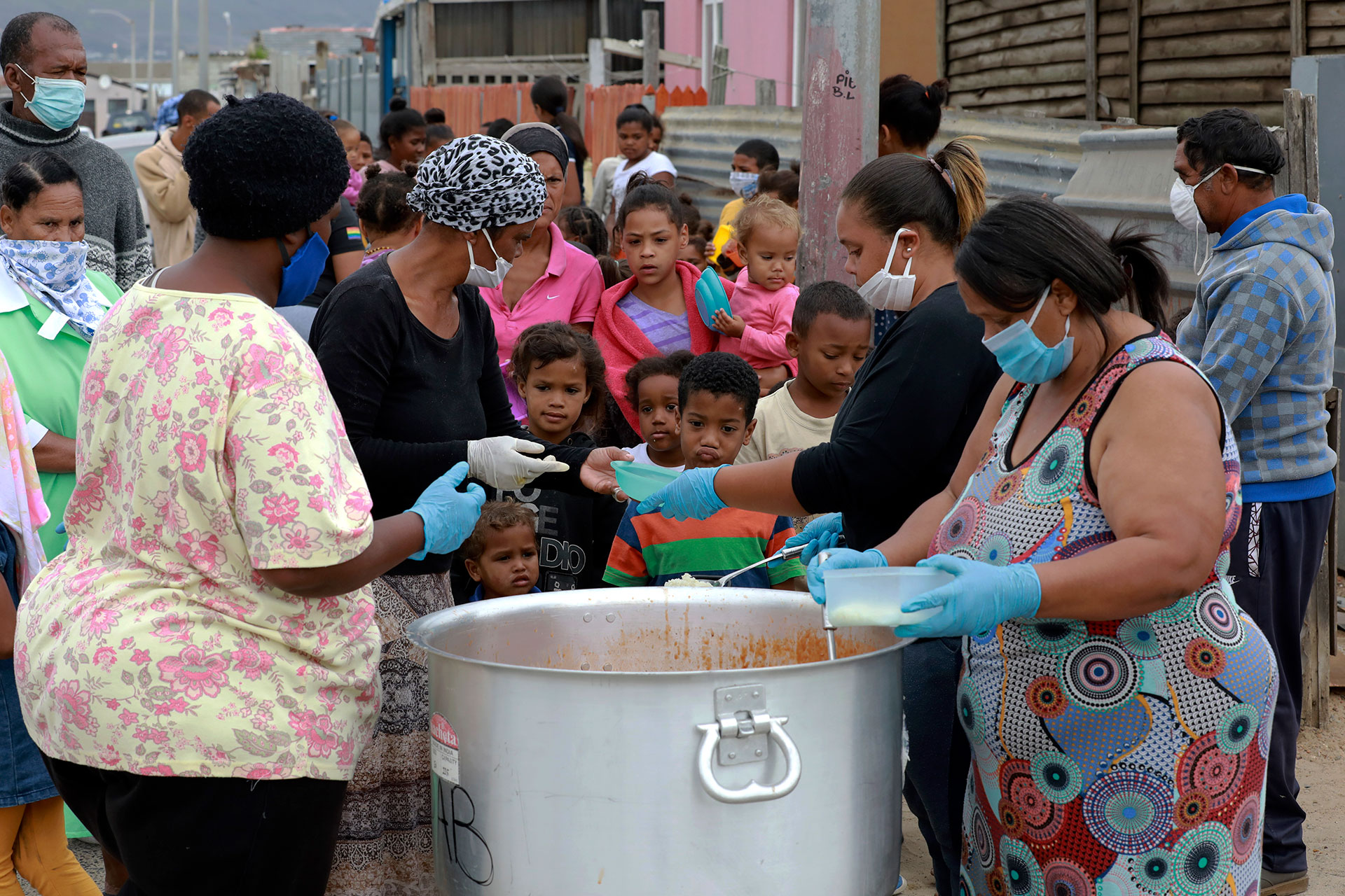 Varios niños hacen fila para recibir comida en un plan de alimentación en Lavender Hill, Ciudad del Cabo, Sudáfrica, durante el confinamiento por coronavirus