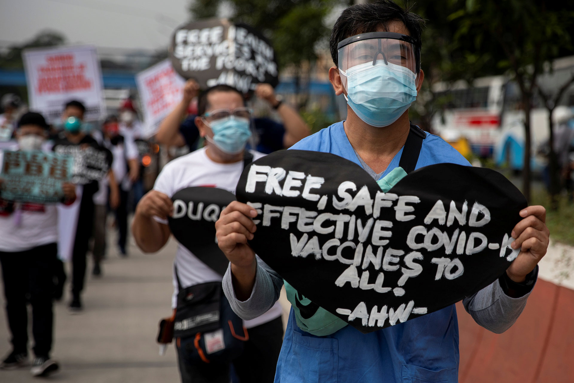 Un trabajador de la salud sostiene un cartel pidiendo vacunas COVID-19 gratuitas, seguras y efectivas durante una protesta en Manila, Filipinas  | © Eloisa Lopez/Reuters/GTres