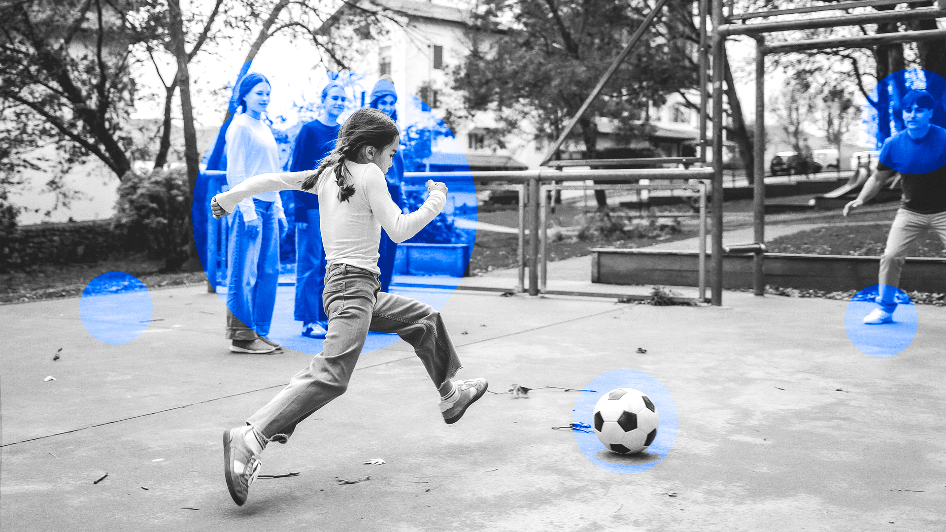 Chicas de varias edades jugando al fútbol en un parque