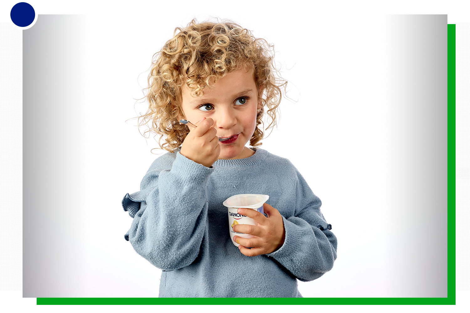 Una niña comiendo un yogurt de Danone