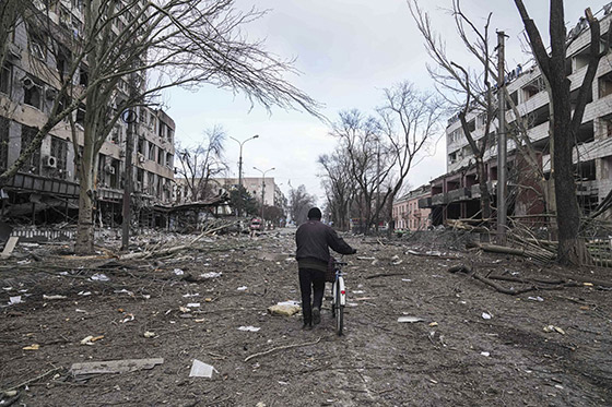 Un hombre camina en bicicleta por la dañada ciudad de Mariupol, Ukraine | © Evgeniy Maloletka - AP Photo