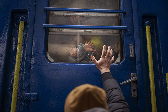 Un hombre se despide de su hijo y de su mujer en la estación de tren de Kiev | © Emilio Morenatti - AP Photo