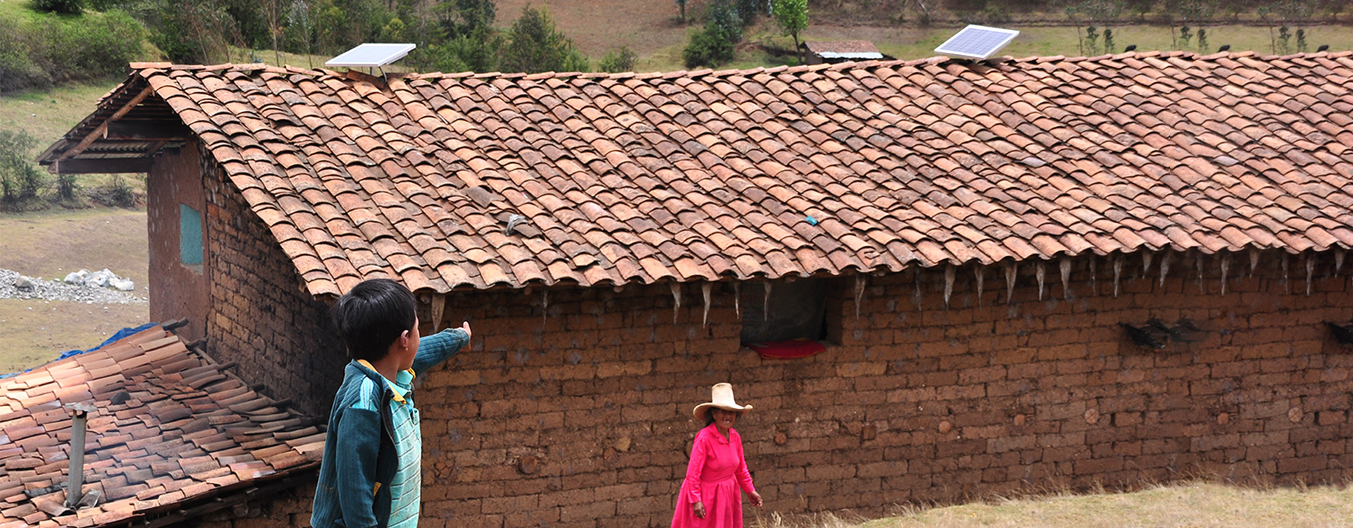 Un niño señala los paneles solares instalados en el tejado de su casa